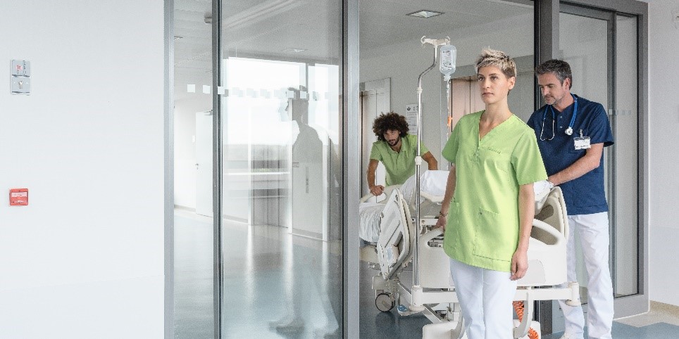 Sfeerfoto van mensen met een zorgtuniek in het ziekenhuis